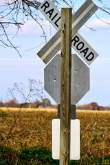 Railroad and stop sign next to field on a road near the Indiana Dunes in autumn