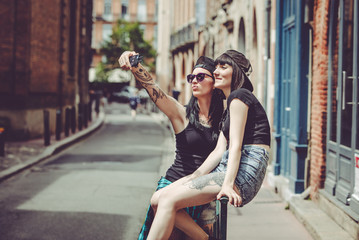 Selfie de deux jeunes femmes  dans un paysage urbain