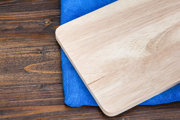 Obraz na płótnie Canvas wooden cutting board and blue cloth on wood table background