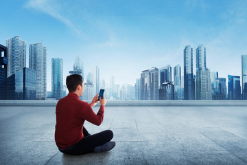 Portrait of asian businessman using a smartphone while sitting on terrace