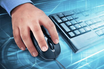 Male hand on computer mouse with keyboard beside him