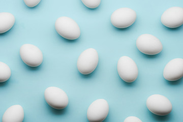 White eggs chaotic pattern on mint color background