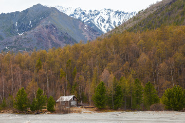 Obraz premium Abandoned wooden house in the forest nearby mountains