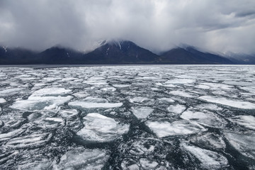 Drifting ice blocks and foggy mountains on background © Aniland
