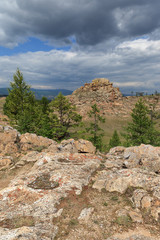 Fototapeta premium Mountain landscape with textured rocks, coniferous trees and heart form in the foreground. View from above