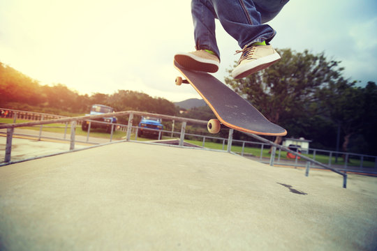 young skateboarder legs practice ollie at skatepark ramp