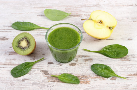 Cocktail from spinach, kiwi and apple on old wooden background, healthy nutrition