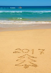 digits  2017 and Christmas tree on the beach