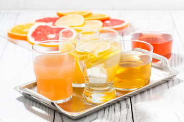 assortment of fresh citrus juices in glasses on white background