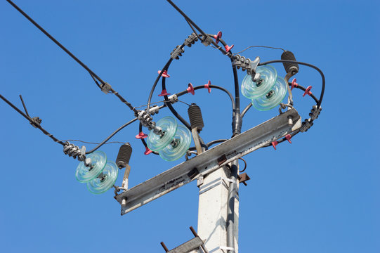 High voltage tower electric post and wires on blue sky background