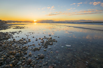 Baltic sea at beautiful sunrise,stony beach after storm