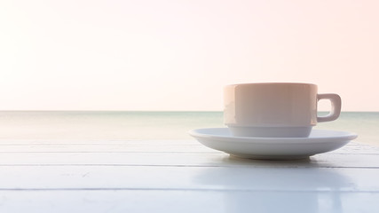 coffee cup on the wooden table with sunset
