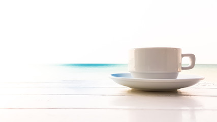 coffee cup on the wooden table with sunflare