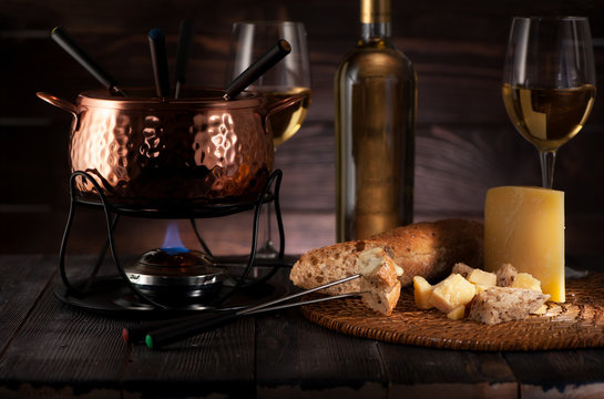 Fondue with cheese and white wine on a dark wooden background