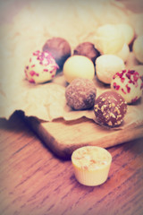 Selection of delicious chocolates on a rustic background
