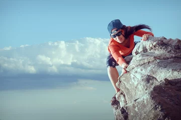 Poster happy woman climbs a rock while trekking outdoors. carefree backpacker smiling at camera © 6okean