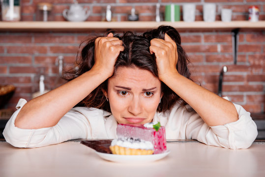 Woman on the diet craving to eat cake. diet concept