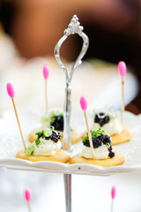 Canapes with smoked salmon and caviar on white plate