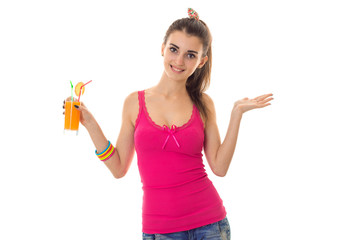 beautiful young girl in a pink shirt smiling and holding in his hand the juice isolated on white background