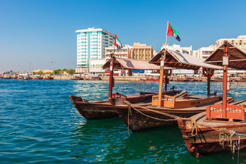 Piers of traditional water taxi boats in Dubai, UAE. Panoramic view on Creek gulf and Deira area. Famous tourist destination United Arab Emirates