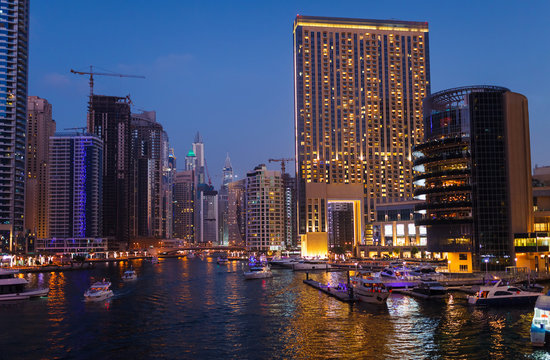 Panoramic night view on downtown of Dubai Marina with modern high skyscrapers. Architecture of future with bright lights and roads. Famous tourist destination