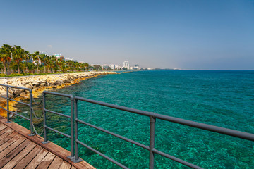 Obraz premium Coastline and promenade in Limassol, island Cyprus, Europe, Mediterranean Sea. Bright sunny day and blue water and sky.