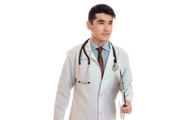 fashionable young man doctor in uniform with stethoscop on his neck looking aside and posing isolated on white background