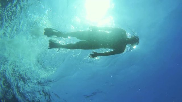 GoPro - Man floating on water, bottom of the sea POV.