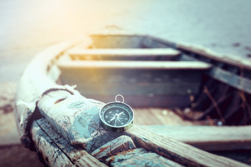 Travel concept, compass, sand and rope on wooden background