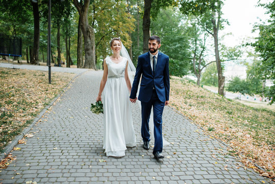 Wedding couple walking on path at green park.