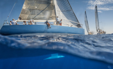 Blue sailing boat on the sea with keel under water - obrazy, fototapety, plakaty