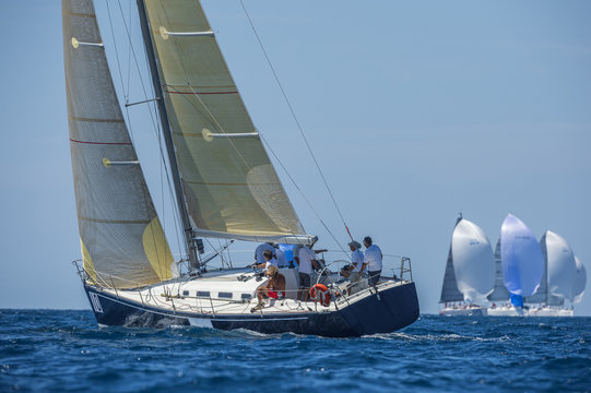 Racing boat with carbon sails sailing up wind