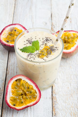 Smoothies passion fruit, milk and chia seeds in a glass with a straw.