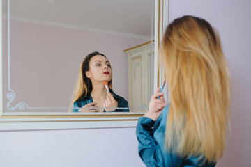 Fototapeta premium applying dry cosmetic tonal foundation on the face using makeup brush.