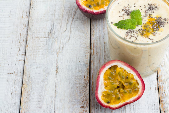 Smoothies passion fruit, milk and chia seeds on a white table.