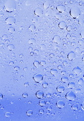 Abstract water drops on a white background with blue light