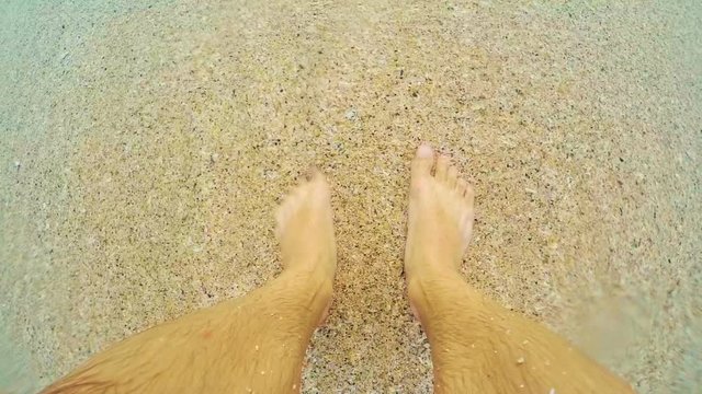 feet in the sand on the beach.
