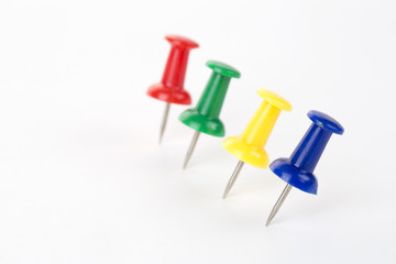 Four pins in different colors on the white background