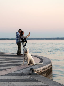  young couple taking a selfie during sunset on Lake Garda. Italy