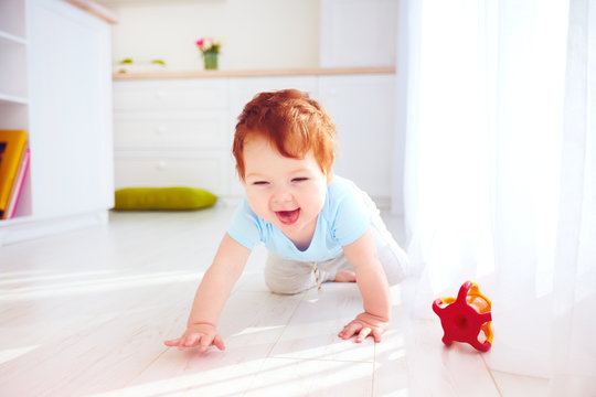 cute ginger baby boy crawling on the floor at home