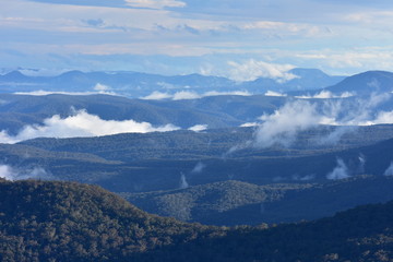 Blue Mountains with low patchy clouds in evening light.