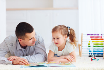 Fototapeta premium happy father and daughter spending time together by reading interesting book