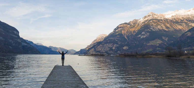 Female figure with open hands. Female figure with open hands. Lake between the mountain ranges. Mountain landscape in the evening.