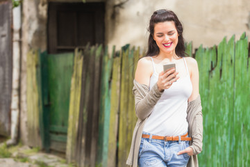 Cute girl using cellphone on the street.