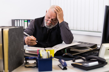 Mann am Schreibtisch mit Stress und Burnout