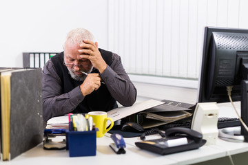 Mann am Schreibtisch mit Stress und Burnout