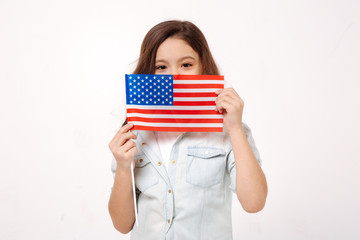 Shy child holding American symbolic in the studio