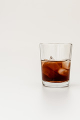 Fototapeta na wymiar closeup of a glass with rum on ice, isolated on white background