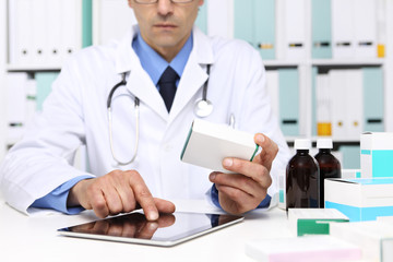Doctor reading a Digital Tablet with drug boxes in hand  at Office Desktop. Health care, Medical...