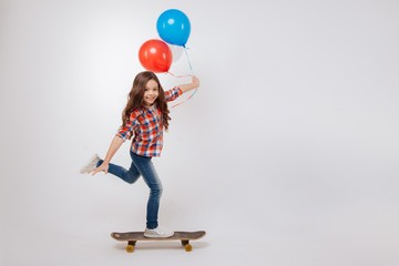 Outgoing girl using skateboard in the studio